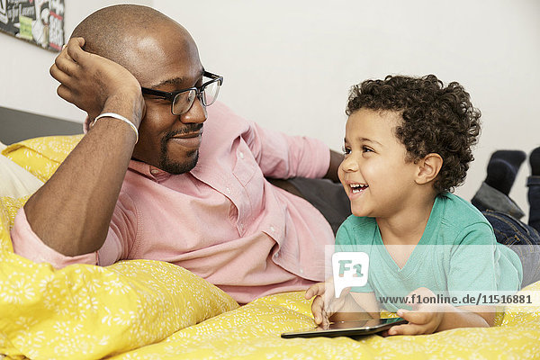 Vater Beobachtet Seinen Sohn Der Auf Dem Bett Liegt Und Ein Digitales