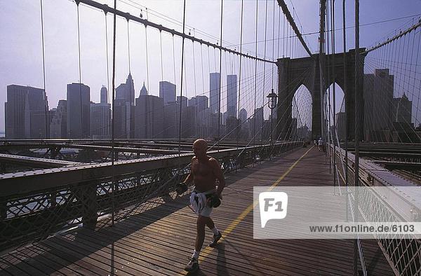 Man jogging on bridge with weights  Brooklyn Bridge  Manhattan  New York City  New York State  USA