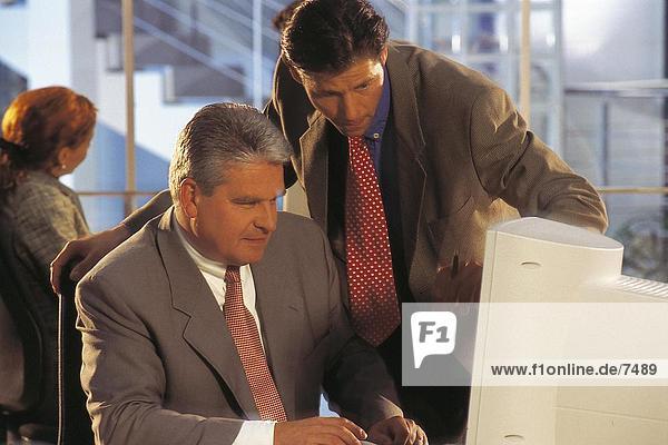 Zwei Geschäftsleute auf Computer im Büro arbeiten