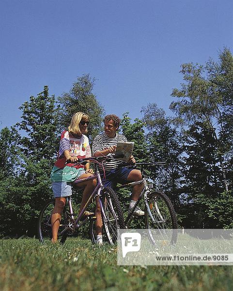 Couple reading road map on bicycles