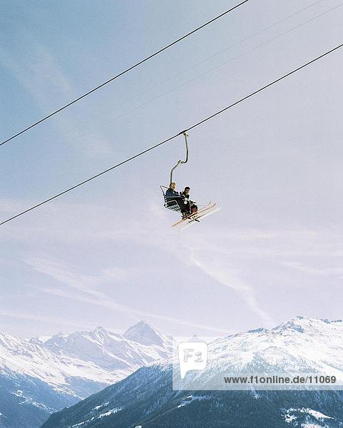 Low angle view of two people on ski lift  mountains Alps  Veysonnaz  Switzerland