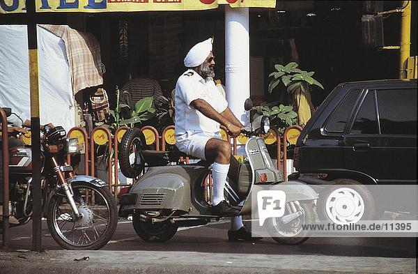 Side profile of man on motor scooter  Madras  India