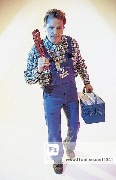 Porträt eines Mannes hält eine Rohrzange und ein Tool-box