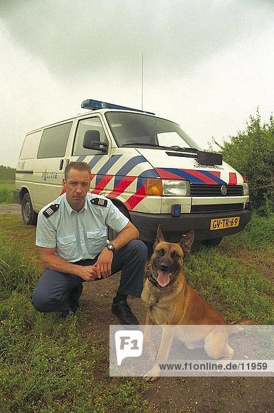 Policeman with dog in front of police car  Netherlands Europe