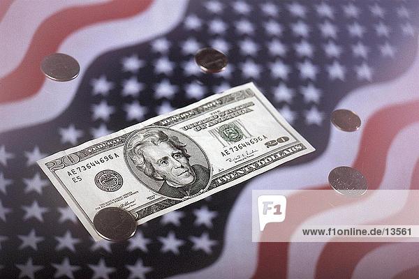 Nahaufnahme von uns Münzen und zwanzig Dollar-Schein auf amerikanische Flagge
