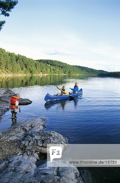 Man rowing canoe in lake with son  lake Ragnerudsjoen  Kroppefjaell  Dalsland  Sweden