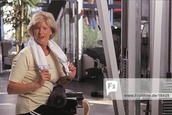Portrait of mature woman resting in gym