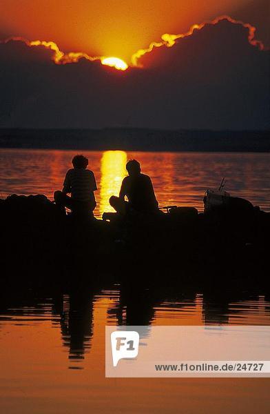 Silhouette von zwei Personen Angeln im See bei Sonnenuntergang  Plattensee  Ungarn