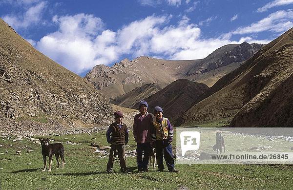 Children standing on landscape with dog  Kirgistan