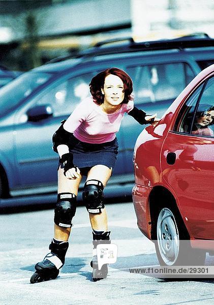 Young woman inline skating on the road