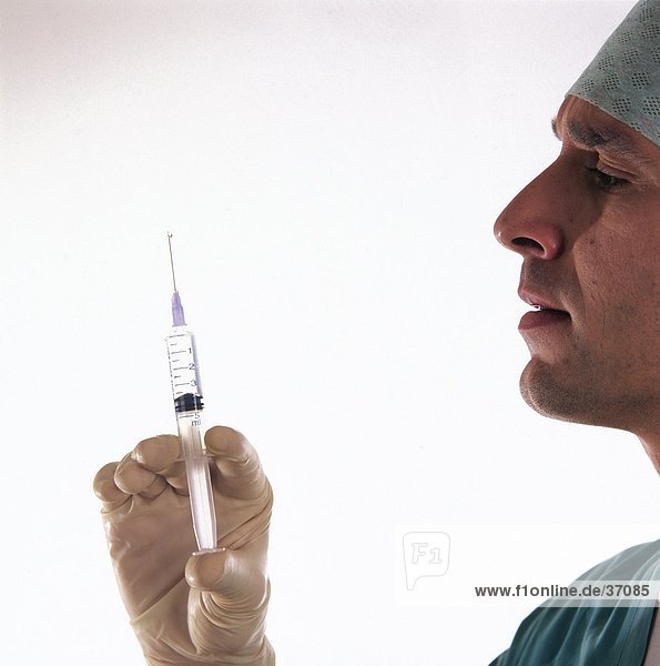 Nahaufnahme von einem männlichen Arzt hält eine Spritze