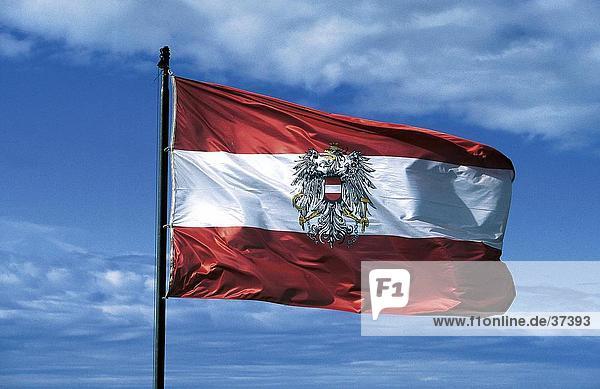 Austrian flag fluttering against cloudy sky  Untersberg  Salzburg  Austria