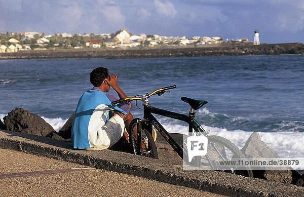 Mann sitzen am Meer  St. Peter Port  Reunion  Frankreich