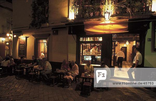 Tourists at restaurant during night  Barrio de Santa Cruz  Seville  Andalusia  Spain
