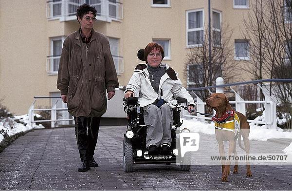 Weibliche mit Behinderten Frau und Hund auf Straße