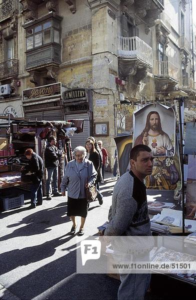 People in street  scene souvenir stand  Valletta  Malta