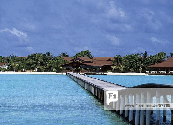 Pier in das Meer bei bewölktem Himmel Dhigufinolhu Malediven