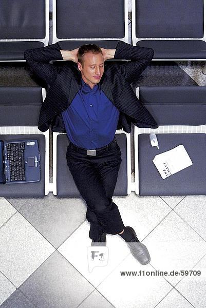 Erhöhte Ansicht des Kaufmanns schlafen im Wartezimmer am Flughafen