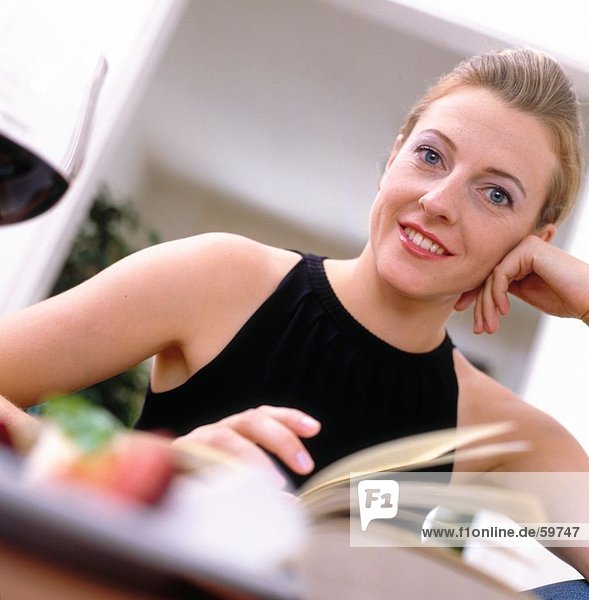 Portrait einer jungen Frau lächelnd am Tisch