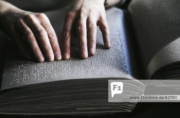 Nahaufnahme der Person Hände lesen Braille