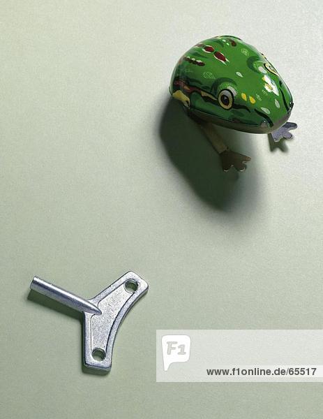 Close-up of toy frog and wind-up key