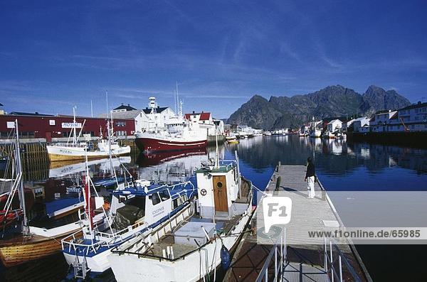 Person standing on a pier at the port  Fjords  Henningsvaer  Lofoten Islands  Norway