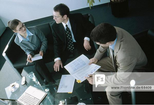 High angle view of businesswoman and two businessmen discussing in meeting