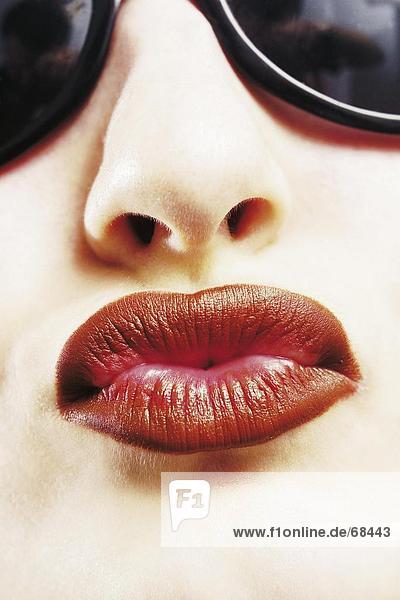 Junge Frau mit Sonnenbrille und roten Lippen  detail