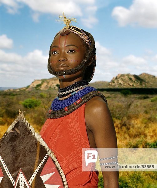Massai-Kriegerin hält Schild  Kenia