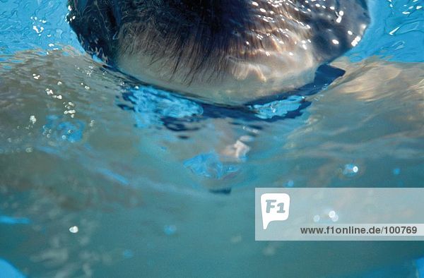 Close-up of male swimmer swimming in swimming pool