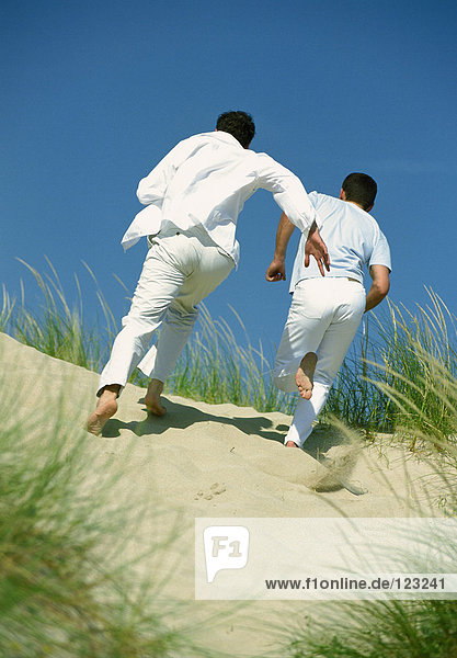 Men running in the dunes