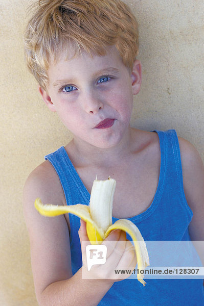 Junge isst Banane