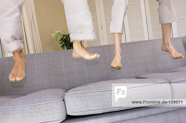 Füße hüpfen auf dem Sofa
