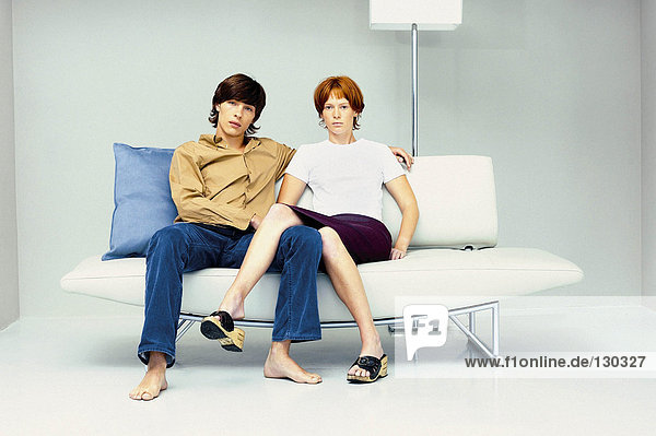 Mann und Frau dicht beieinander auf dem modernen Sofa