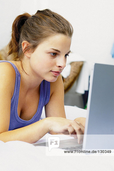 Teenager-Mädchen auf Laptop-Computer
