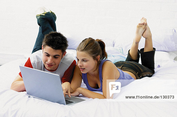 Teenage boy and girl on laptop computer