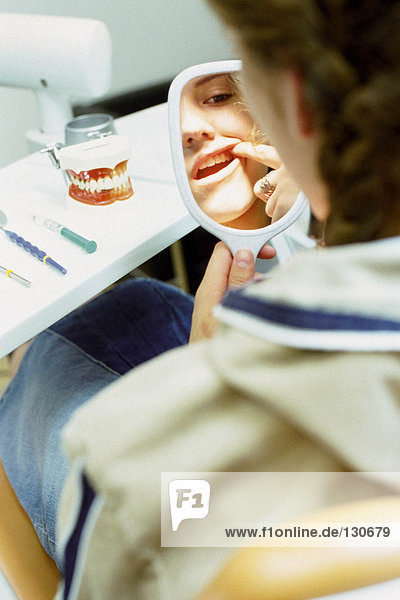 Mädchen untersucht ihre Zähne