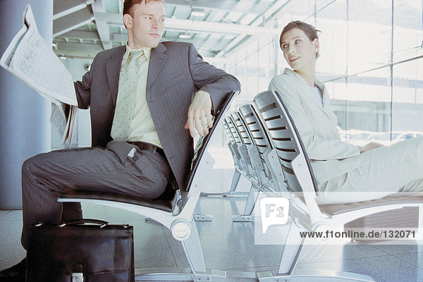 Geschäftsmann und Geschäftsfrau treffen sich in der Airport Lounge
