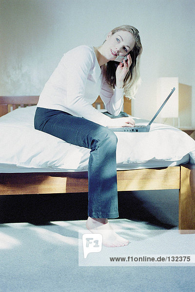 Woman in bedroom with laptop