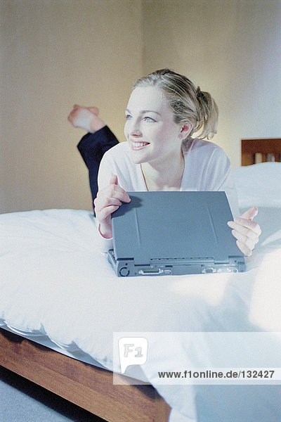 Frau im Schlafzimmer mit Laptop