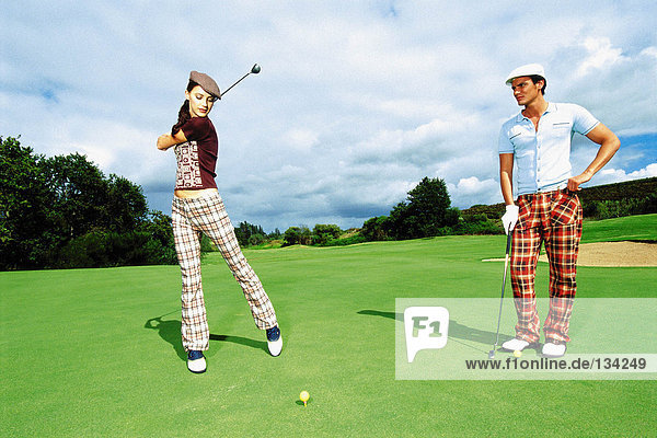 Mann und Frau beim Golfen
