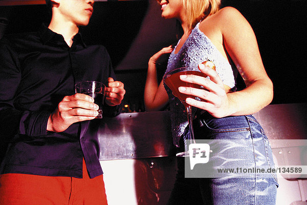 Mann und Frau mit Getränken im Nachtclub
