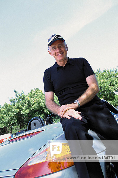 Portrait of a senior man and a convertible