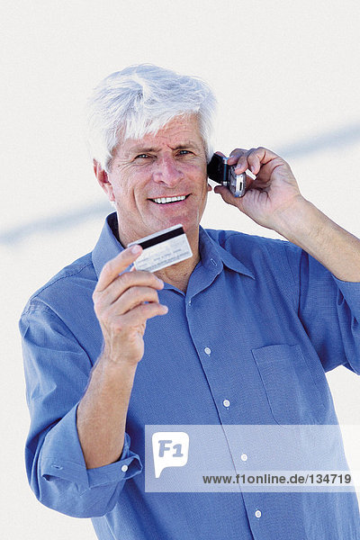 Senior mit Handy und Kreditkarte