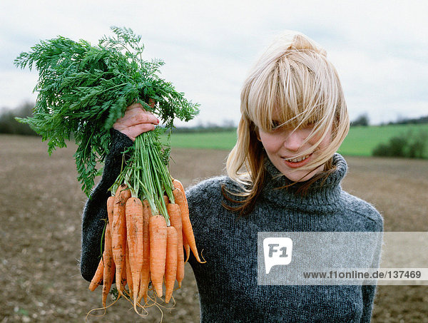 Farmer zeigt stolz ihre Karotten