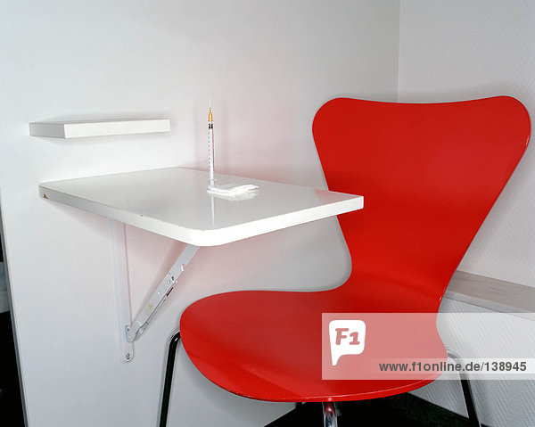 Roter Stuhl und Spritze