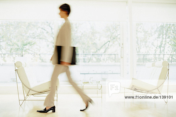 A businesswoman walking fast through trendy waiting room