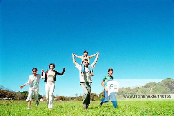Family running in meadow