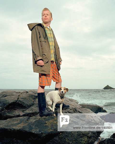 Junger Mann mit Hund am Meer