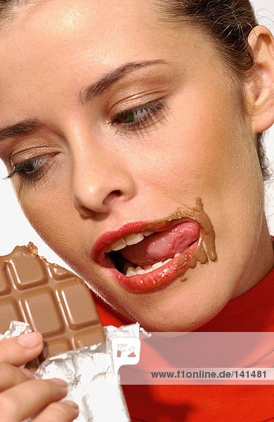 Junge Frau beim Schokoladenessen